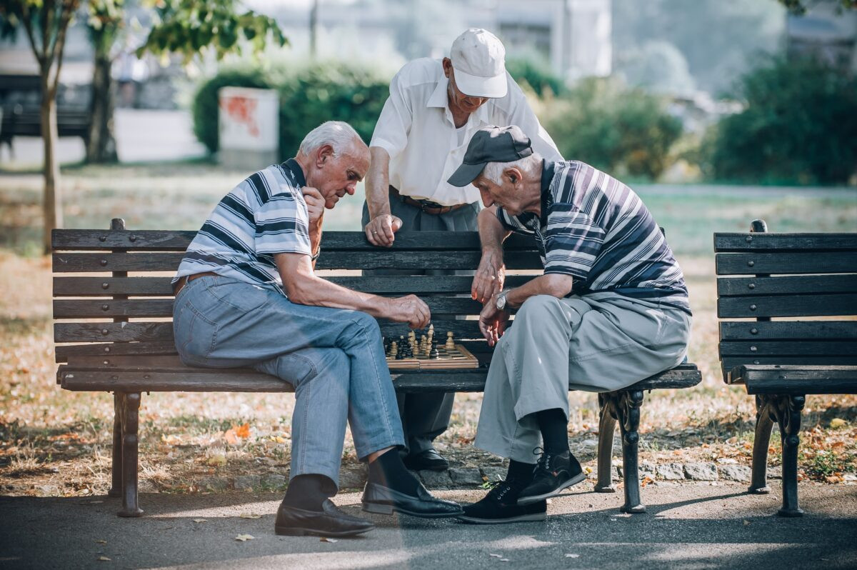 Men playing chess in the park 1200x798