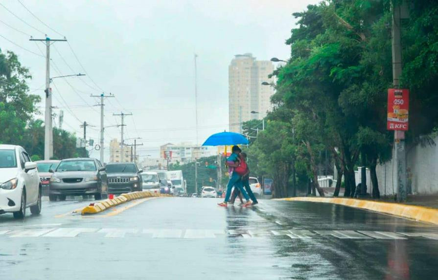Una madre cruzando la calle con sus hijos mientras se cubre de la lluvia con un paraguas 8eb73697 focus 0 0 895 573